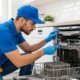 Technician repairing a built in dishwasher in a modern UAE kitchen