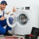A professional technician repairing a front-load washing machine in Dubai SK Technical Services UAE.